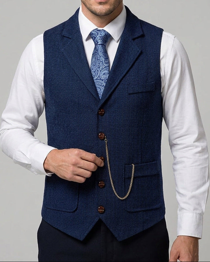 Mann trägt dunkelblaue Lancaster Herren-Weste aus Fischgrat-Tweed mit Uhrenkette über weißem Hemd